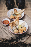 Freshly fried crispy snacks served with tangy tamarind chutney in a cozy kitchen setting.