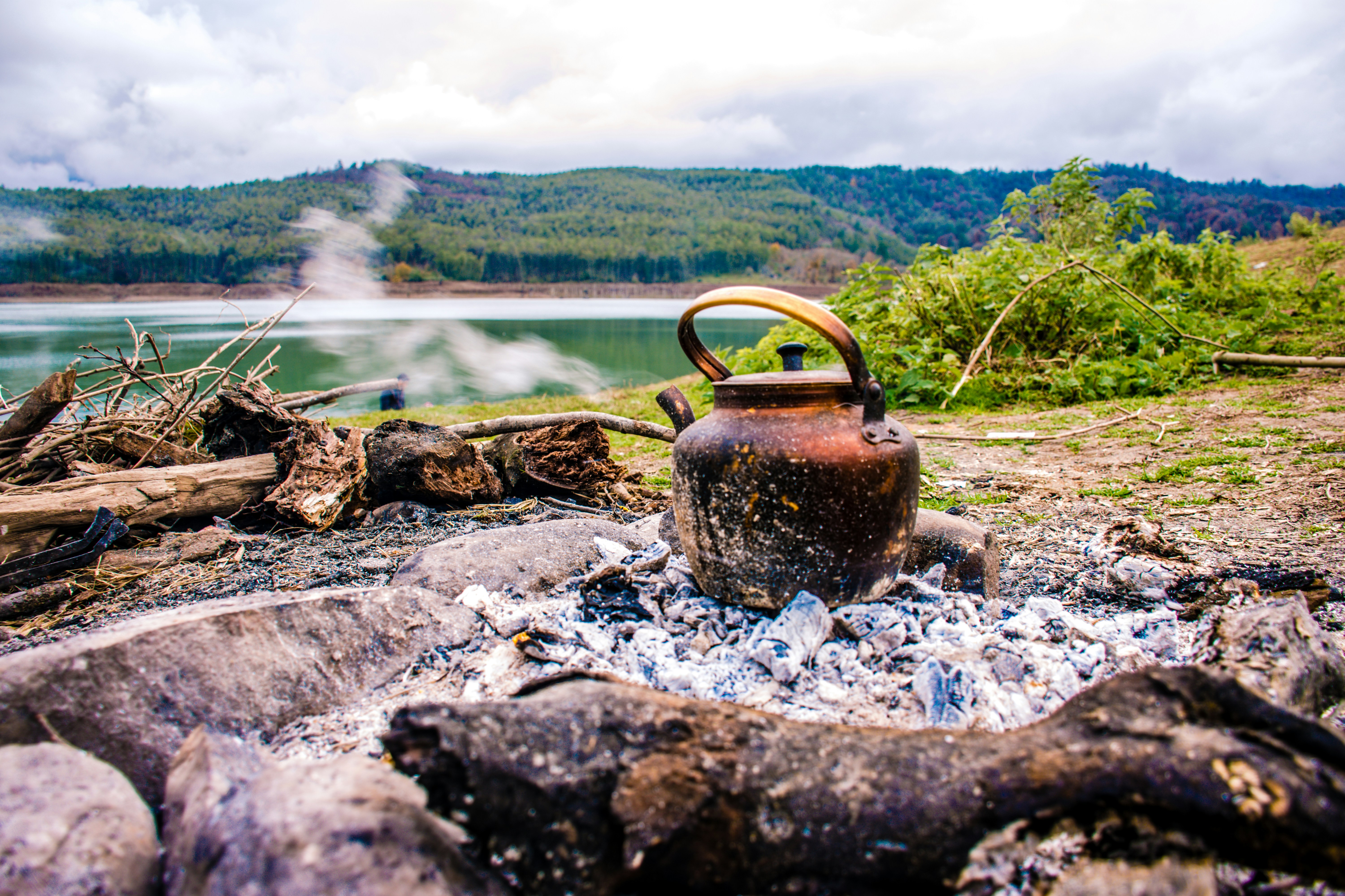 brown kettle on rocky ground near river during daytime