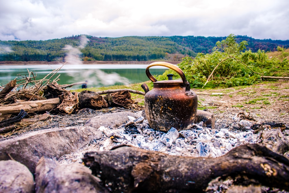 brown kettle on rocky ground near river during daytime