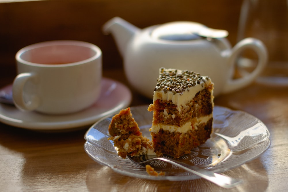 pastel blanco y marrón en platillo de cerámica blanca junto a taza de té de cerámica rosa