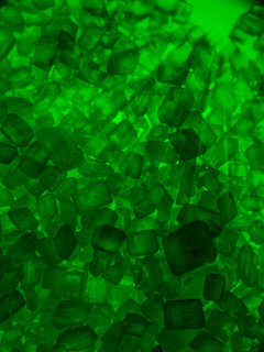 Microscopic view of photonic crystals illuminated with soft green light.