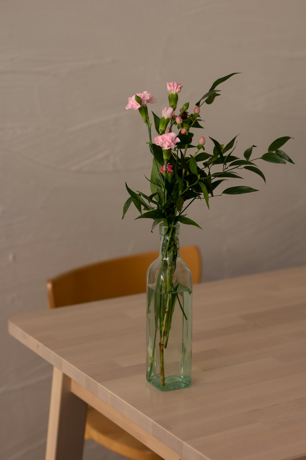 pink and white flowers in clear glass vase on brown wooden table