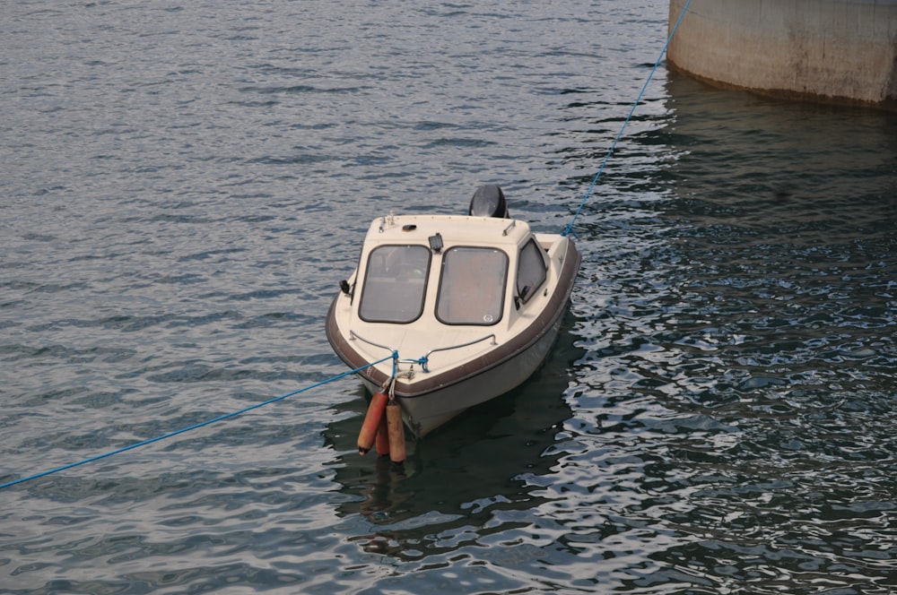 barca bianca e blu sull'acqua durante il giorno