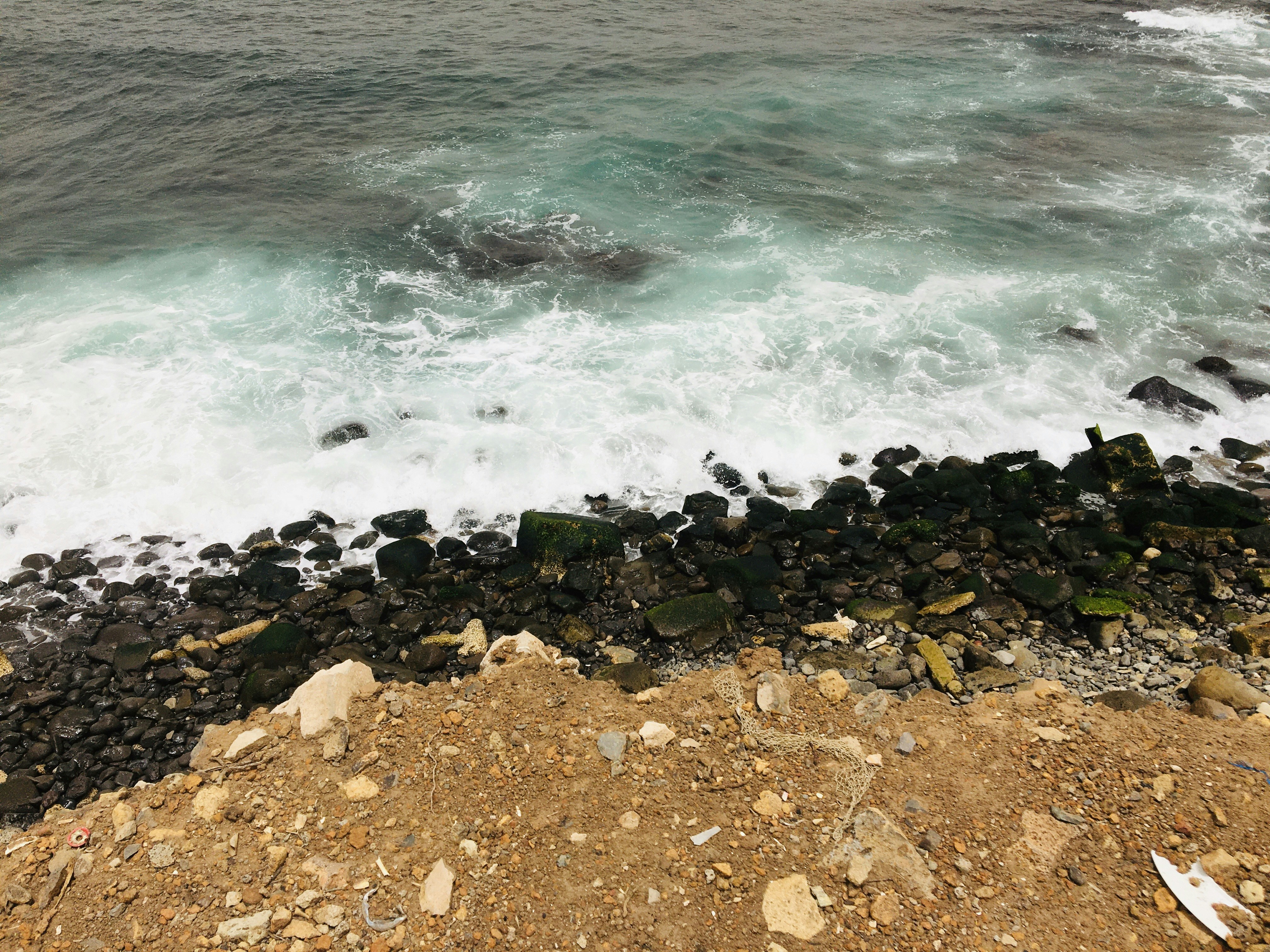 brown rocks near body of water during daytime