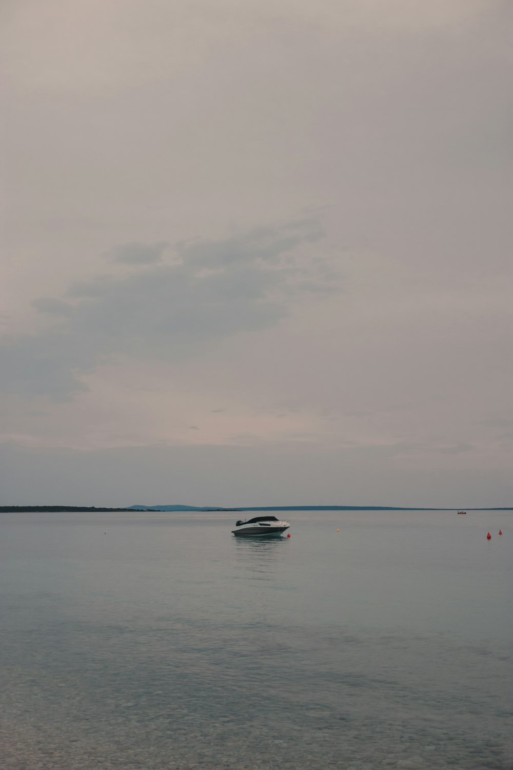 white boat on sea under cloudy sky during daytime