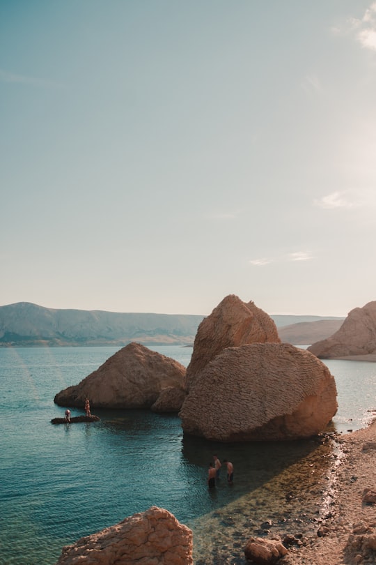 brown rock formation on blue sea water during daytime in Pag Croatia