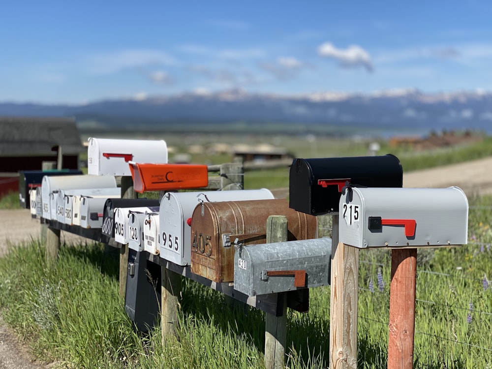 Cassetta postale bianca e rossa su staccionata di legno marrone