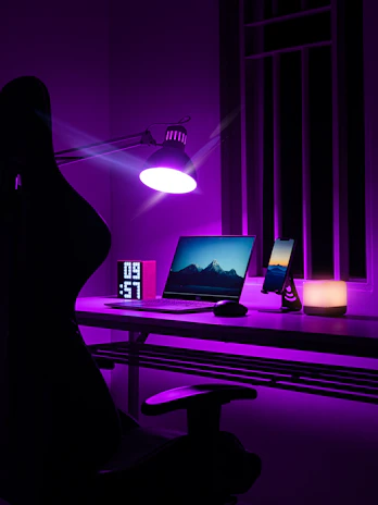 woman in black dress standing near black laptop computer on brown wooden desk