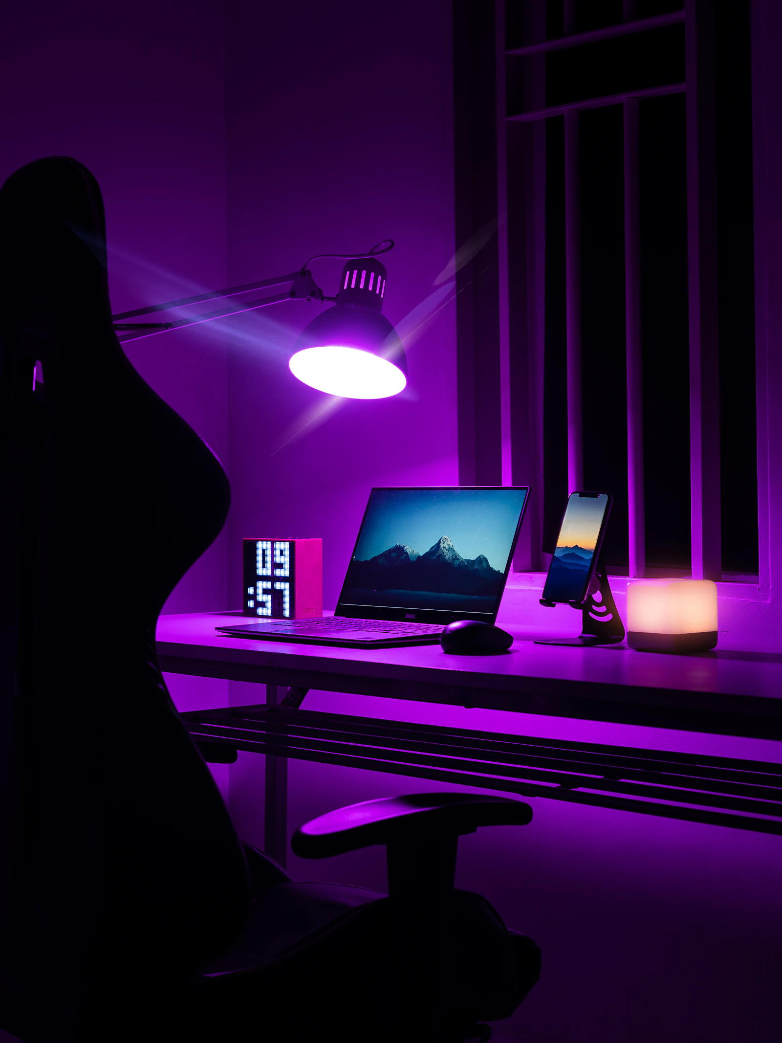 A woman standing near a laptop on a wooden desk