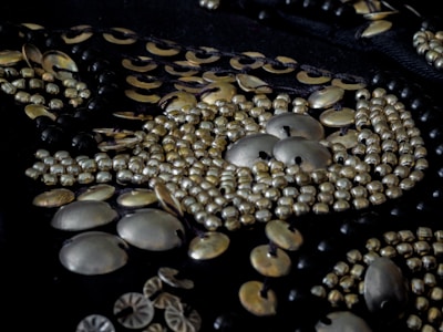 A close-up of luxurious fabrics and detailed beadwork laid out in the boutique.
