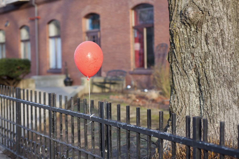 roter Ballon auf braunem Baumstamm