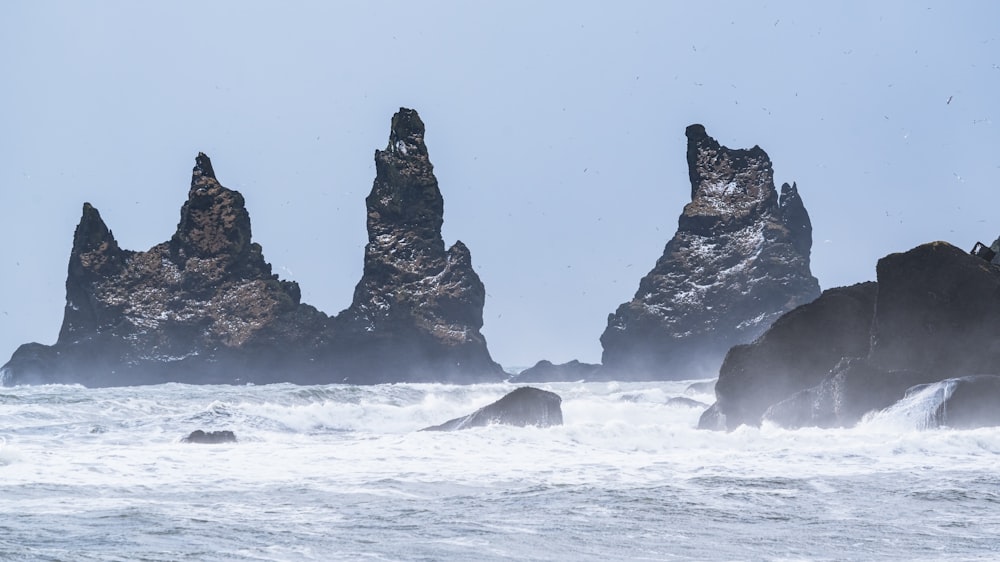black rock formation on sea water during daytime