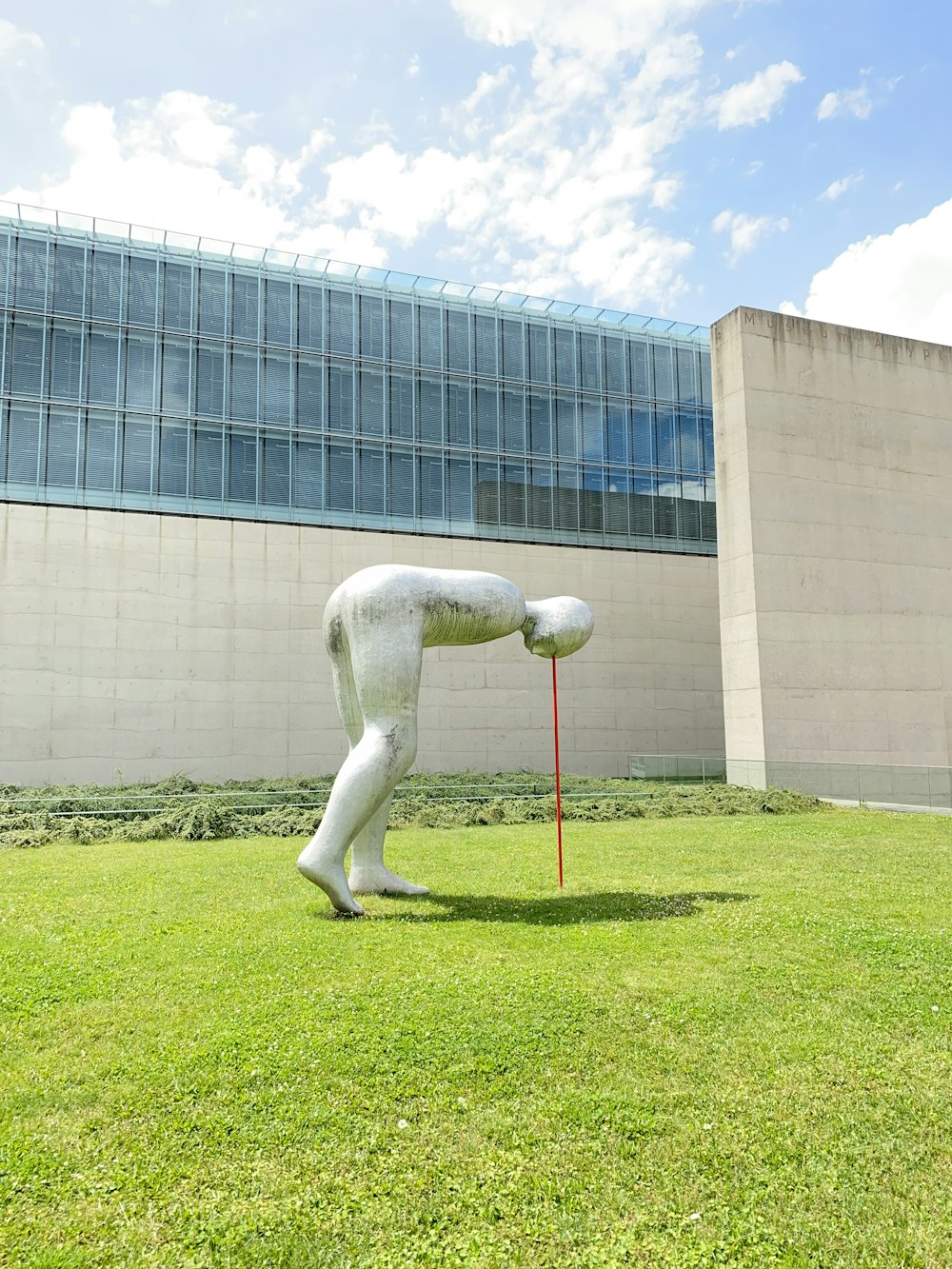 white statue on green grass field near building during daytime