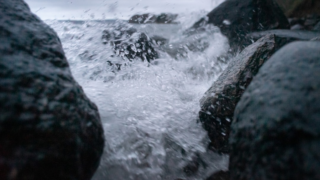 water waves hitting black rock