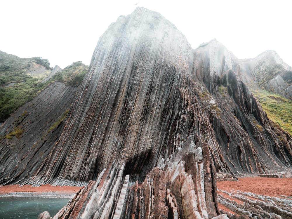 brown and gray rock formation near body of water during daytime