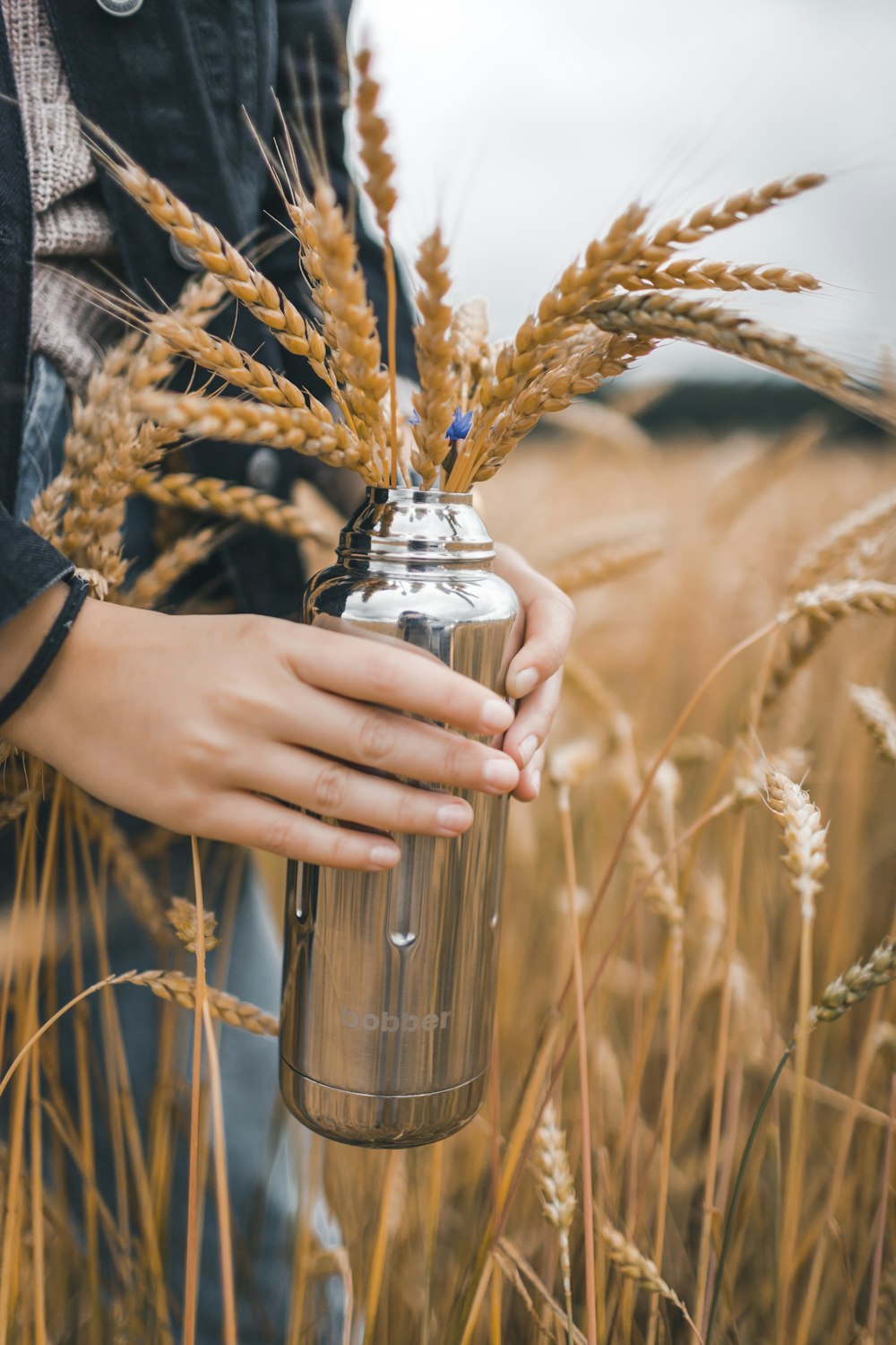 person holding stainless steel vacuum flask