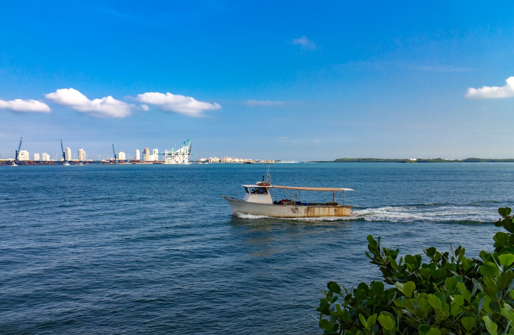 white boat on sea under blue sky during daytime