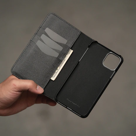 An open leather phone case displaying its smooth interior and secure slots.