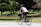 A man cycling through an urban park, dressed in Lumina Apparel’s comfortable and stylish activewear.