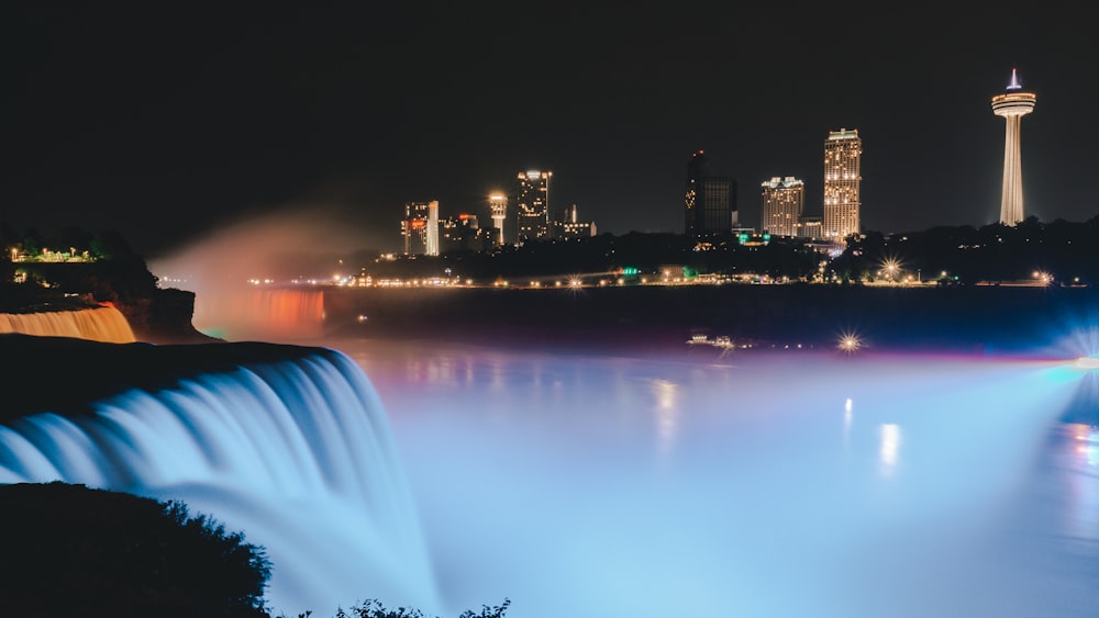 water fountain near city buildings during night time