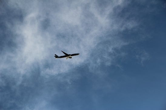 Modern aircraft soaring above clouds under a deep blue sky, symbolizing the journey toward becoming a professional pilot.
