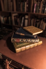 A stack of vintage leather-bound books with a reading lamp.
