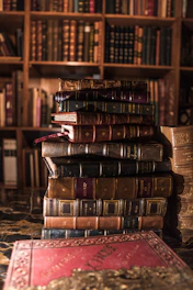 stack of books on brown wooden shelf