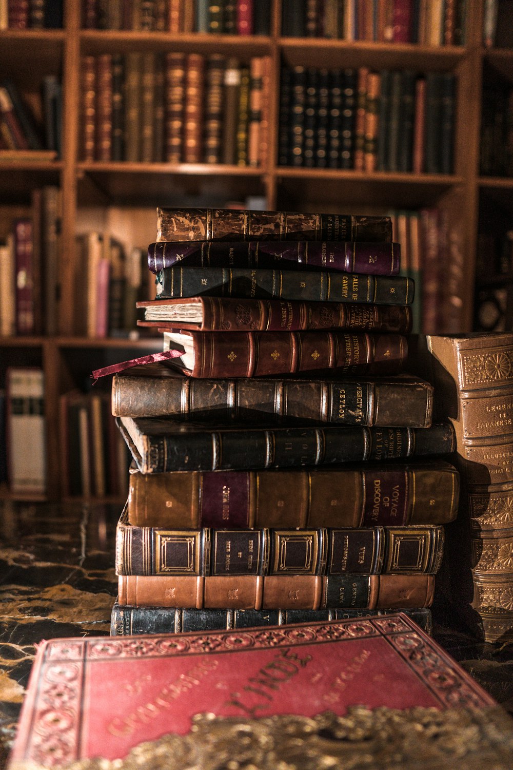 pila de libros en estante de madera marrón
