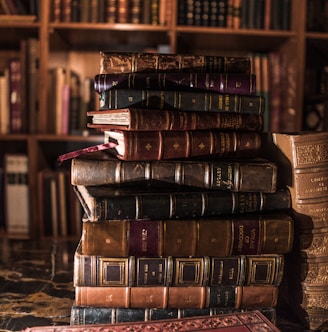 stack of books on brown wooden shelf