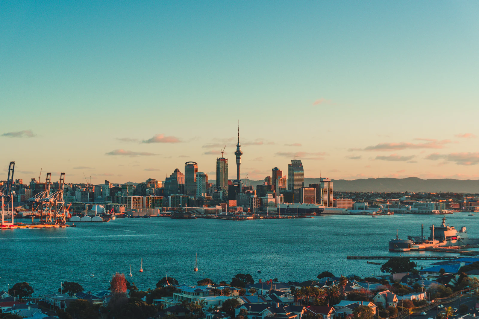 The Auckland skyline and harbor under a warm low sun in New Zealand