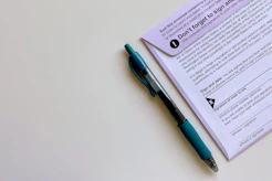 a pen sitting on top of a mail-in ballot envelope