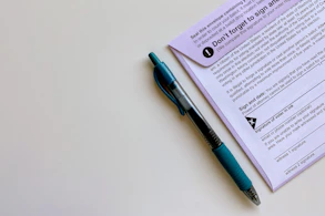 a pen sitting on top of a mail-in ballot envelope
