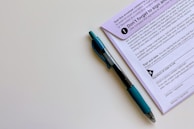 Professional reviewing paperwork with a pen in hand.