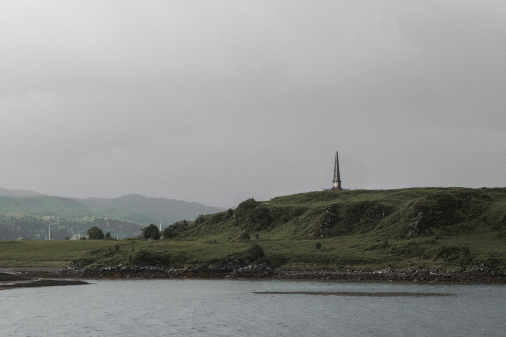 white sailboat on sea near green mountain during daytime