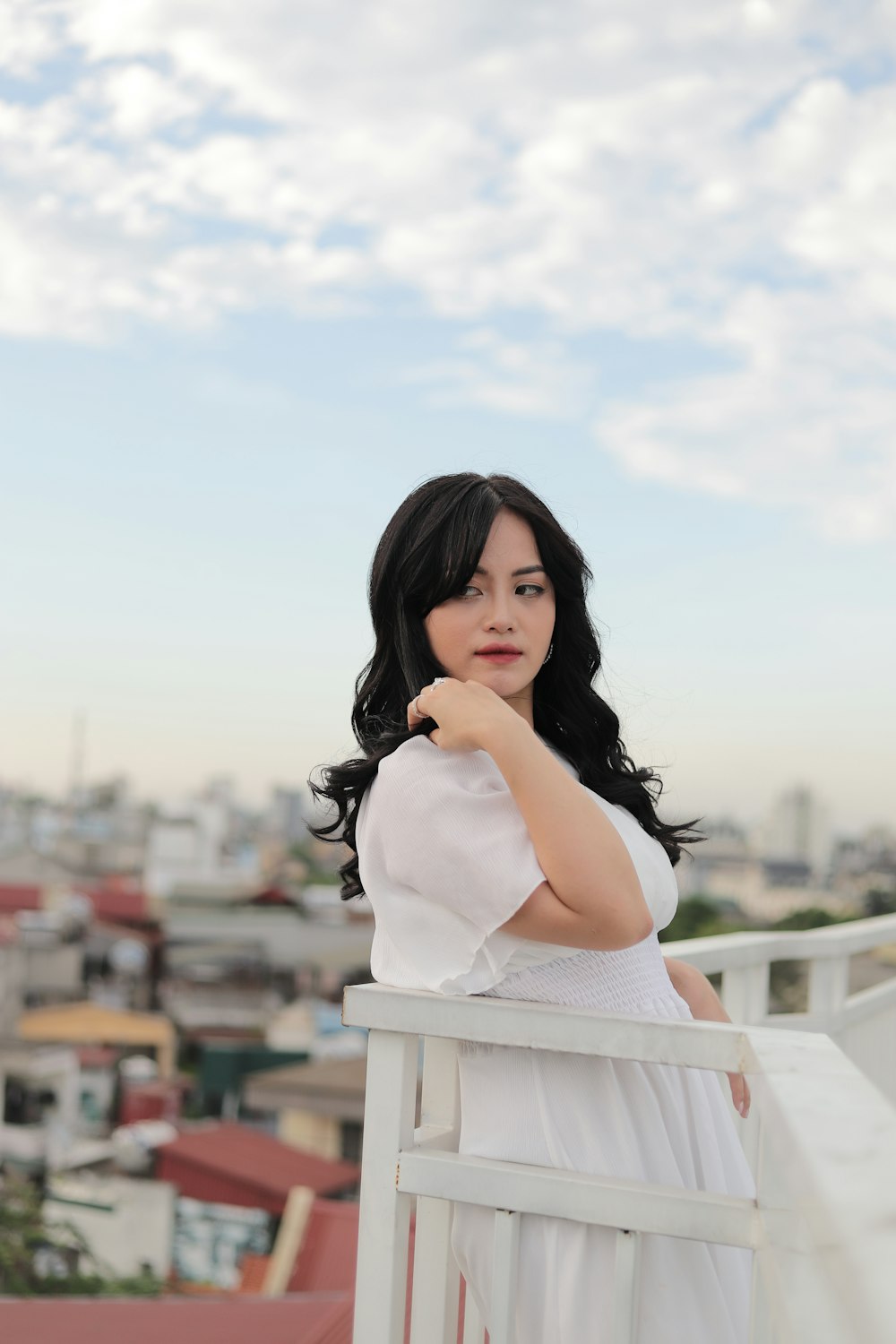 woman in white dress standing on the roof during daytime