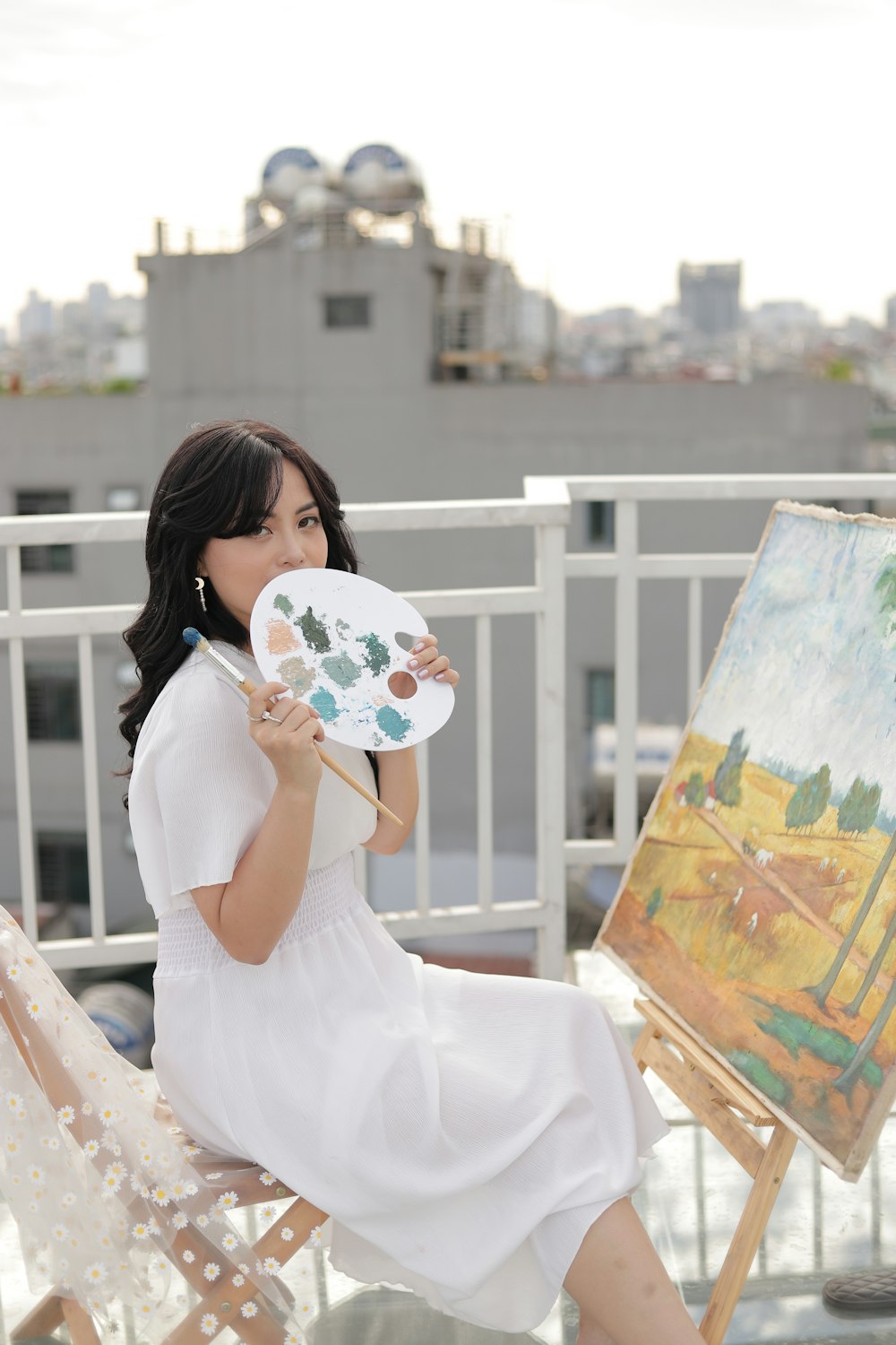 woman in white dress holding white and blue floral hand fan