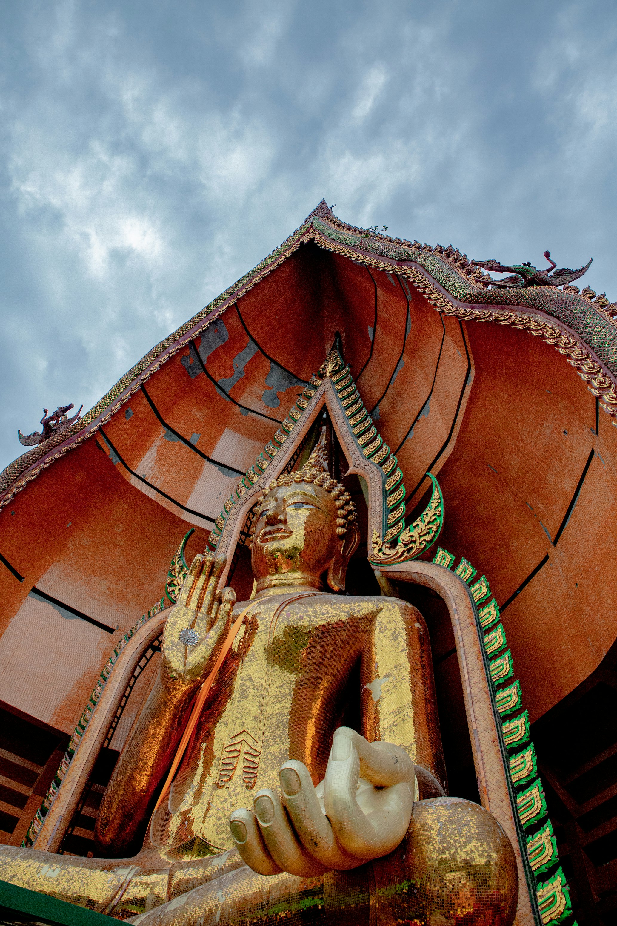 gold buddha statue under cloudy sky during daytime