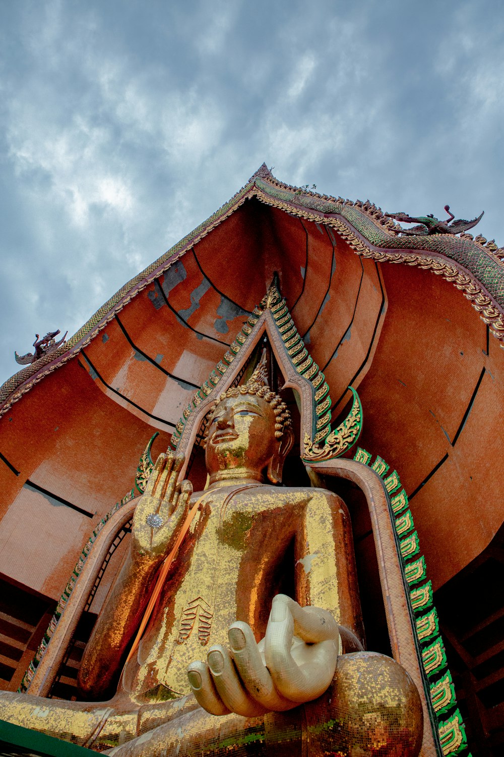 Estatua de Buda de oro bajo el cielo nublado durante el día