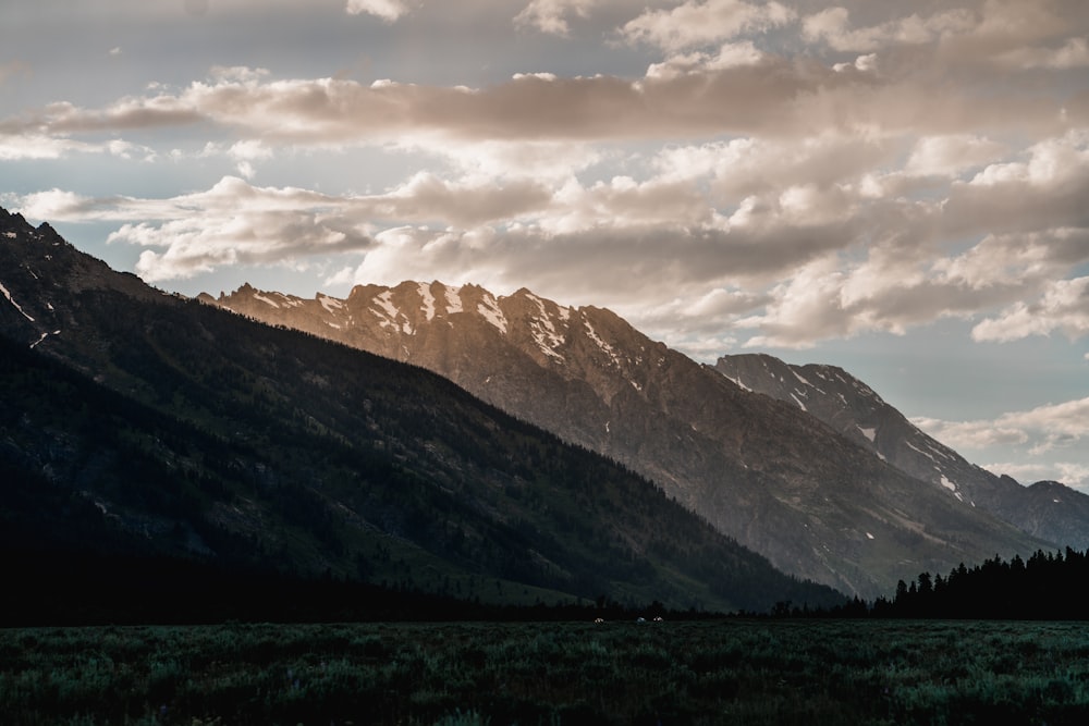 brown and gray mountains under white clouds during daytime