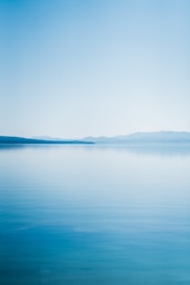 blue body of water under white sky during daytime