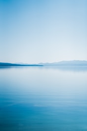 blue body of water under white sky during daytime