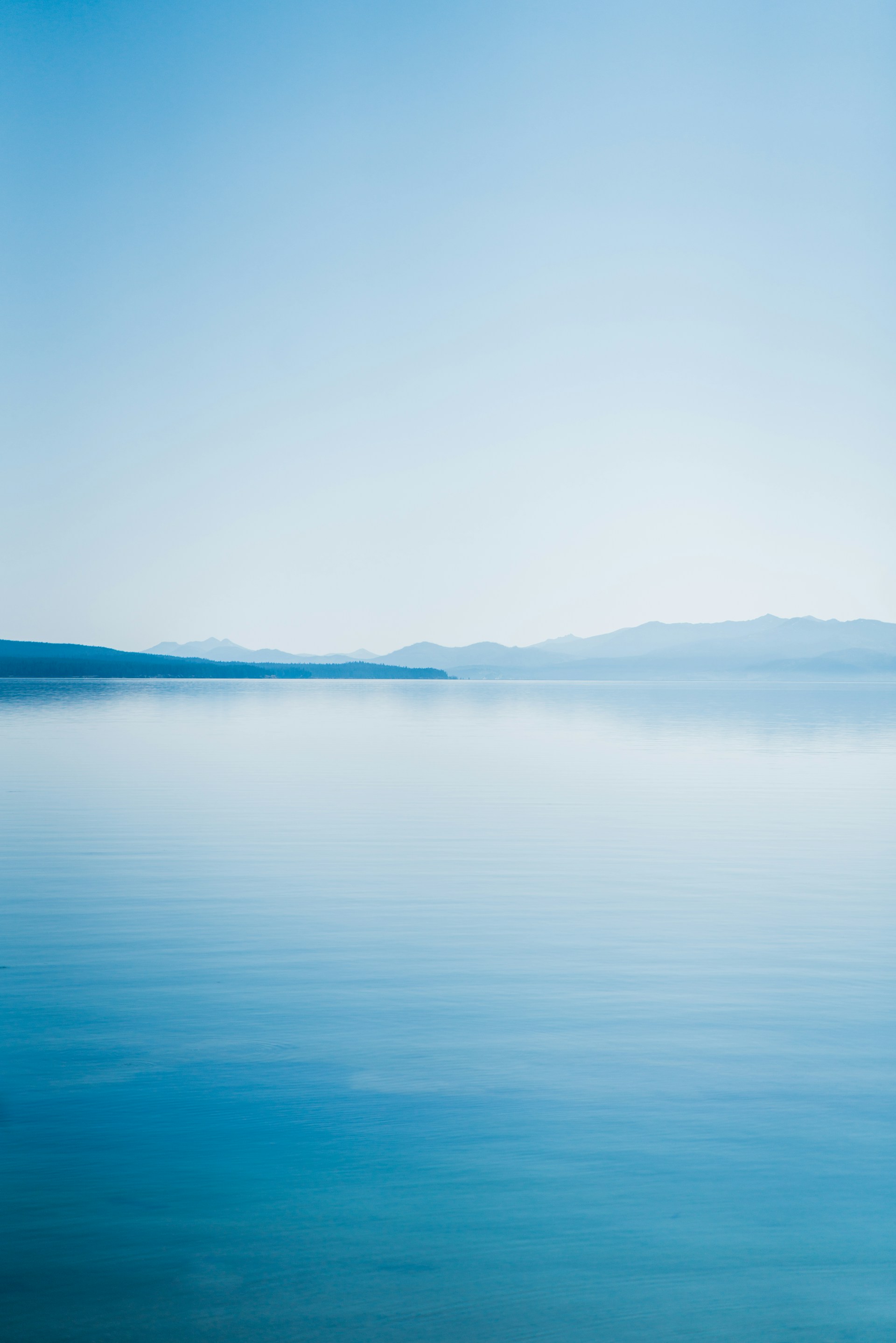 blue body of water under white sky during daytime