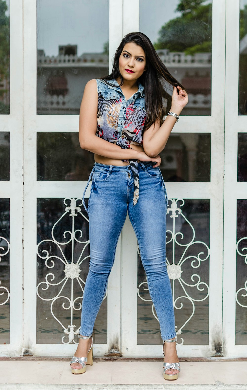 woman in blue denim jeans standing beside white wooden door