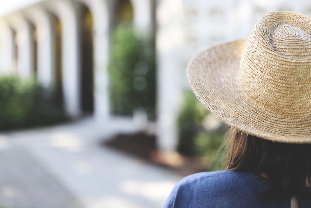 woman in blue shirt wearing brown straw hat