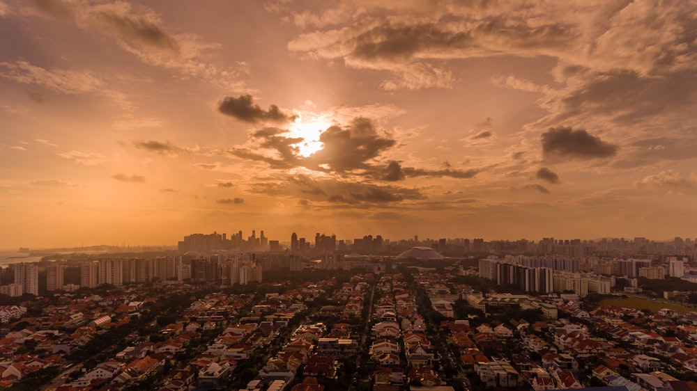 city skyline under cloudy sky during sunset