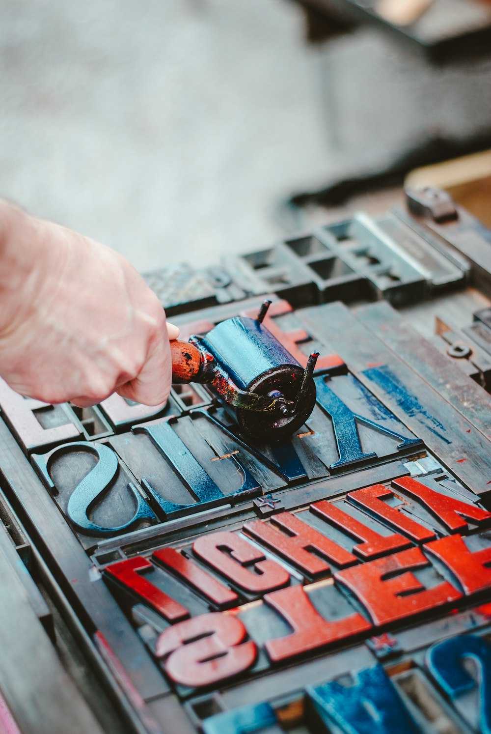 person holding a letterpress roller tool 