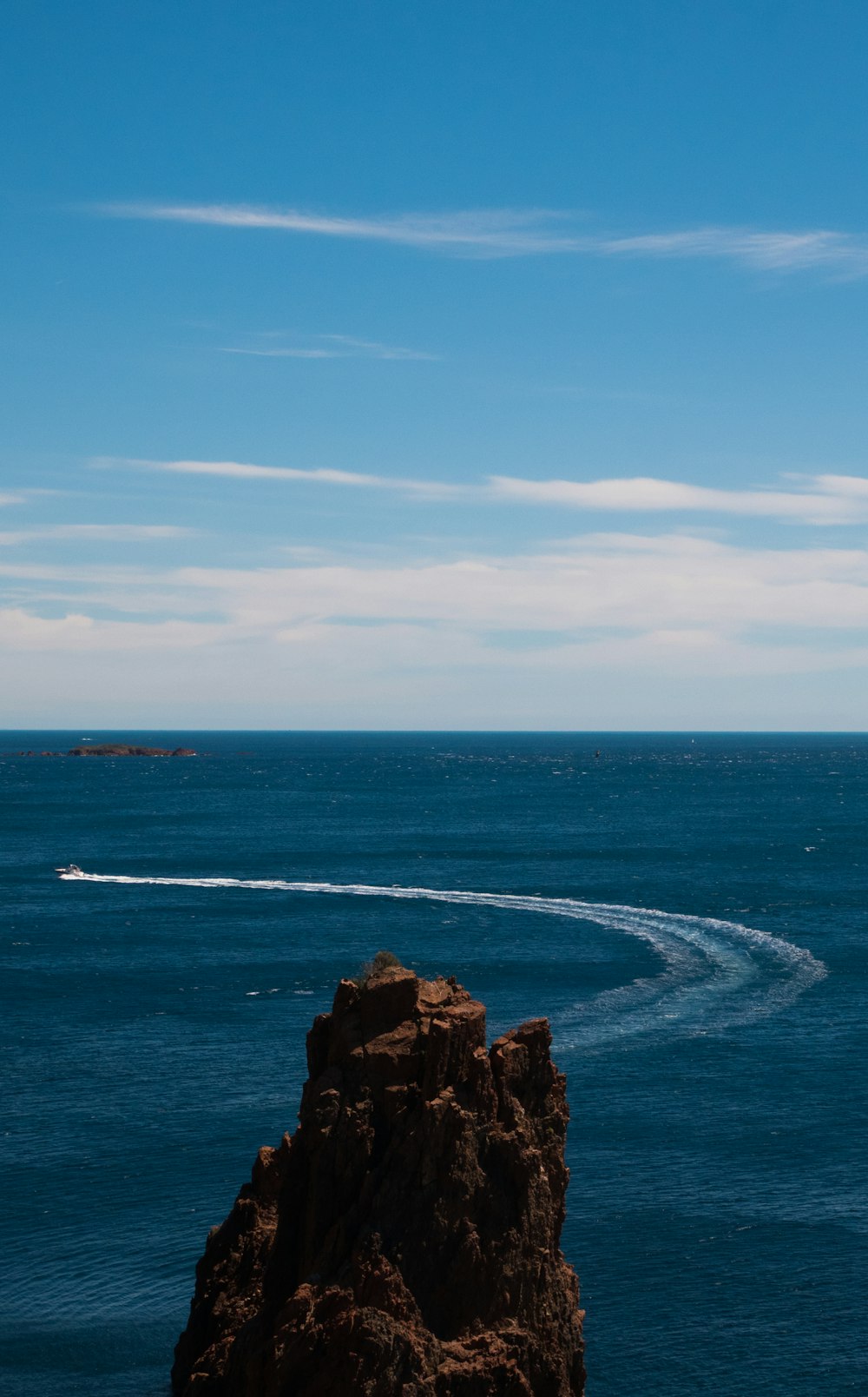 body of water near brown rock formation under blue sky during daytime