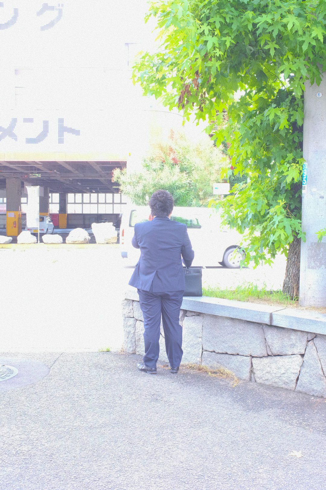 man in black jacket standing near green tree during daytime