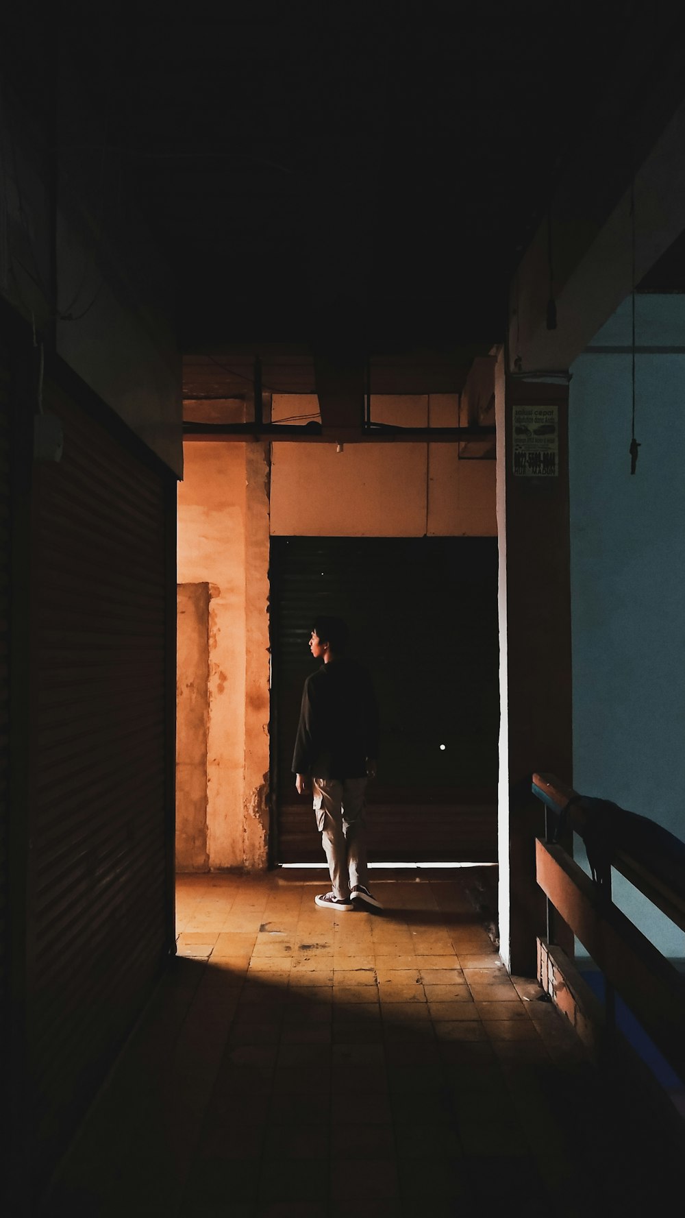 man in black shirt walking on hallway