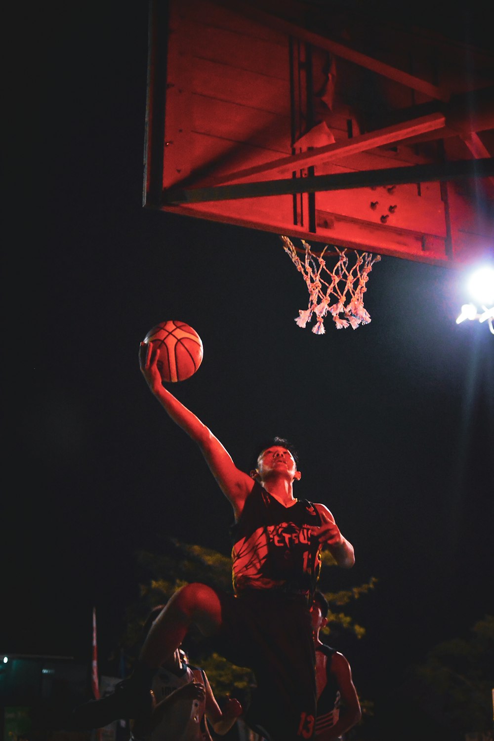 man in red jersey shirt holding basketball